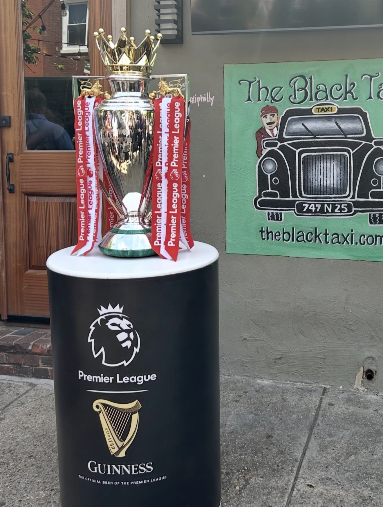 Premier League trophy on display outside The Black Taxi pub in Fairmount