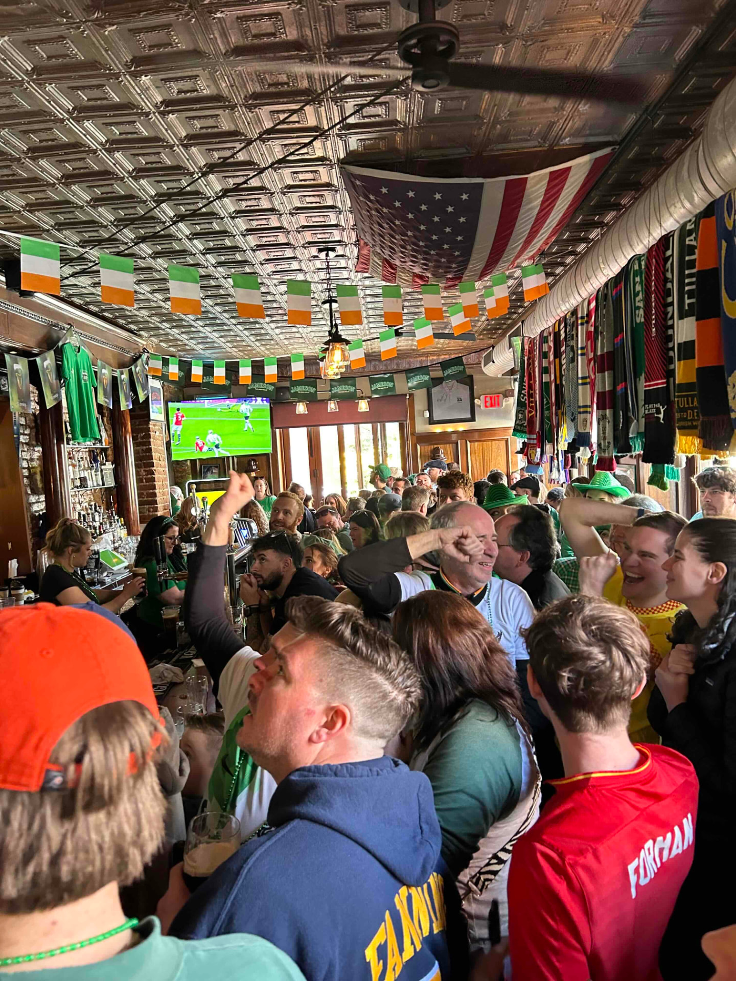 A packed match day inside The Black Taxi, with Irish flags, scarves and soccer on the screens
